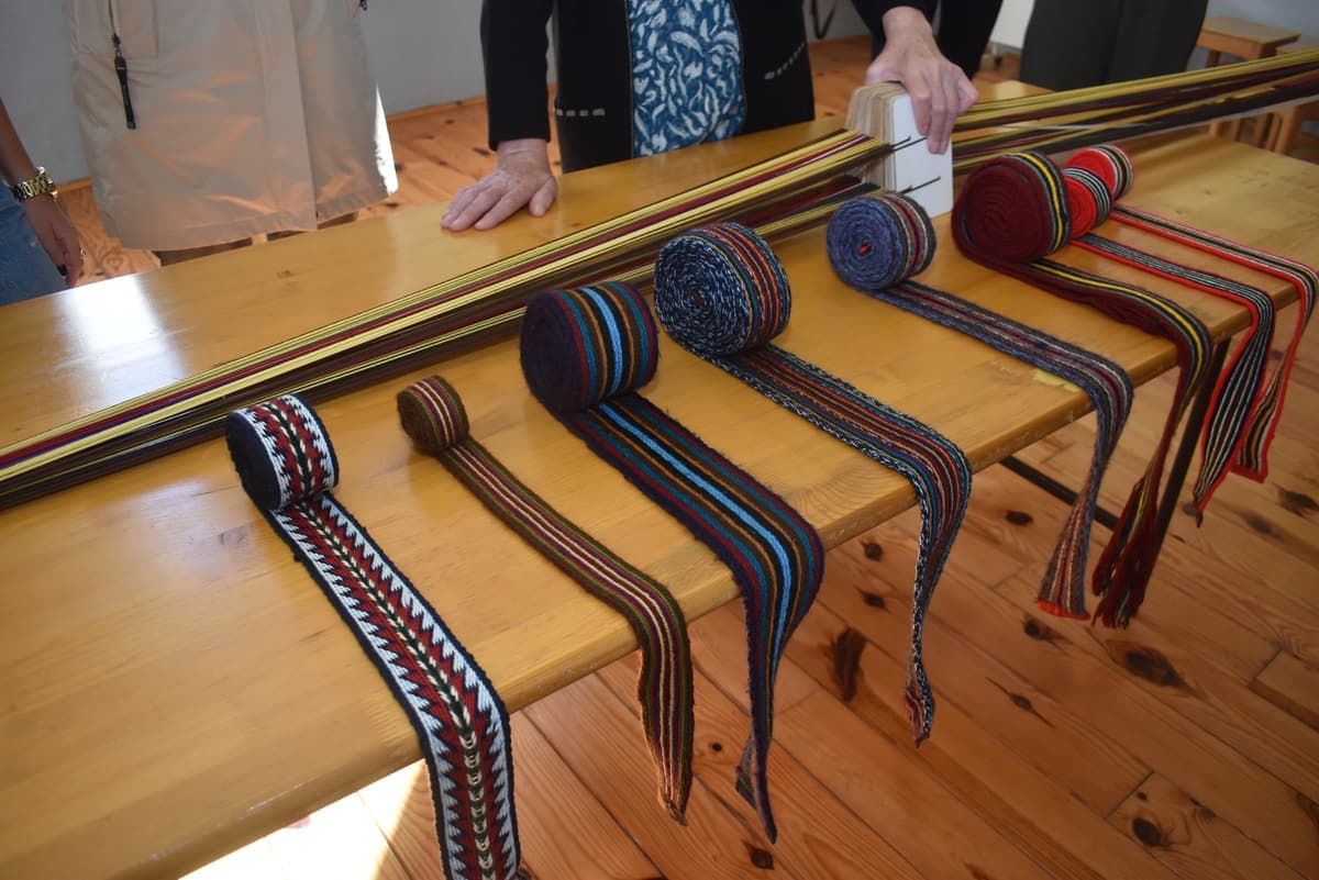 Otkani tradicionalni pojasevi poredani na stolu tokom radionice